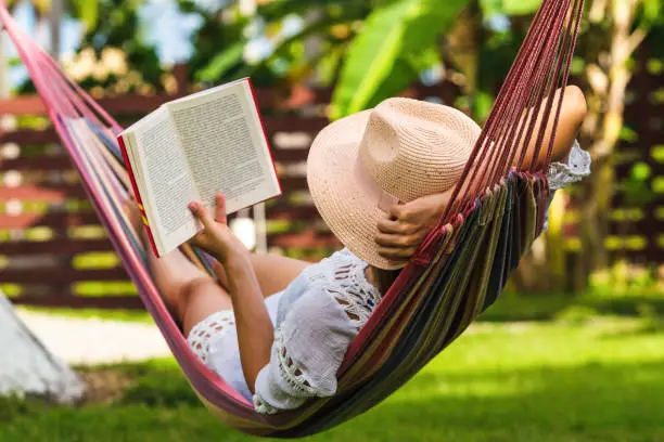 Photo of Woman reading book in hammock