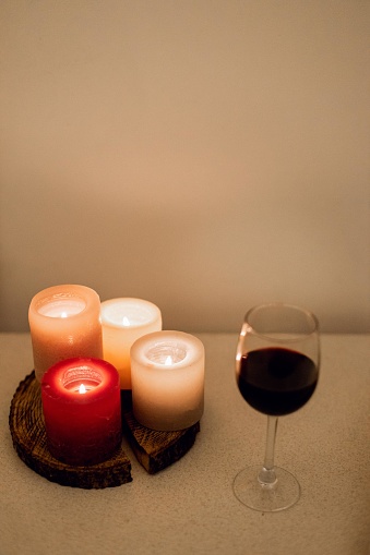 Candles with glass of wine on the table in the evening