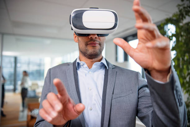 istock Professionally dressed business man using a virtual reality headset in the lobby 1301559039