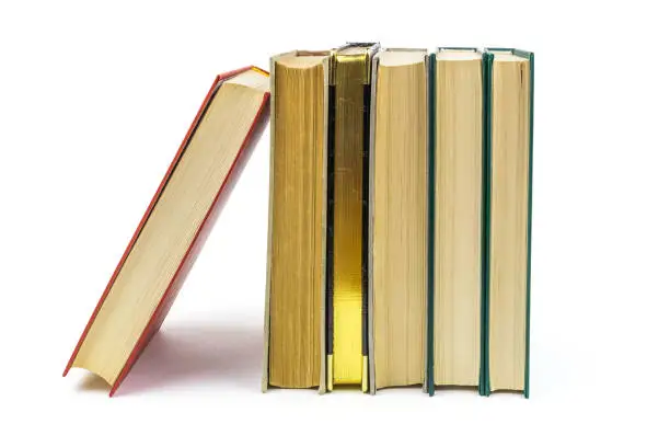 A row of old books with a gold-plated book in the middle isolated on white background. Blank for the designer.