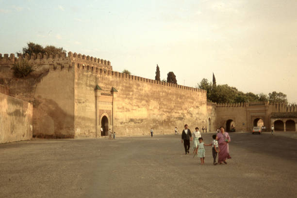 Moroccan family walking in front of the ancient walls of Meknes. Meknes, Morocco - Aug 03, 1989: The ancient walls of the old city of Meknes. arabia photos stock pictures, royalty-free photos & images