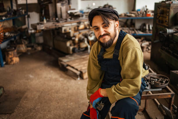 istock Happy professional craftsman standing in workshop with tools 1301560622