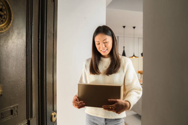 istock Young woman receiving package from delivery man 1301561402