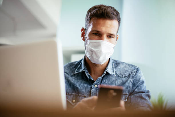 istock Company manager with medical mask sending a message. 1301562303