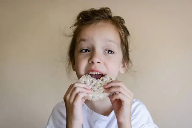 Portrait of a girl eating a rice cracker