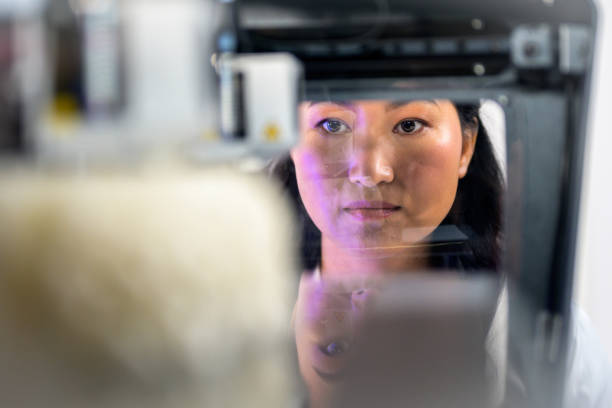 istock Female biomedical engineer observing 3D model of brain in 3D printer 1301565818