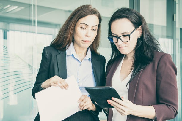 istock Concentrated businesswomen looking at tablet screen 1301565876