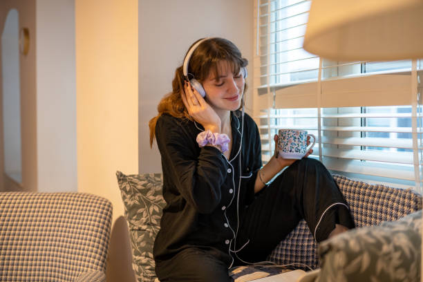 istock Young girl listening music with headphone while drinking her coffee 1301568762