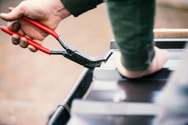 Roofer builder worker finishing folding a metal sheet