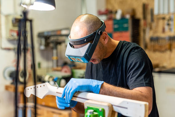 istock luthier at work with precision lenses, craftsman expert in musical instrument making with filing a guitar handle, concept of musical and craftsmanship business, use protection at workplace 1301569622