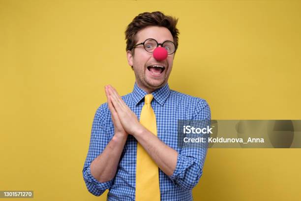 Handsome Young Man With Red Clown Nose Smiling And Clapping Hands Stock Photo - Download Image Now