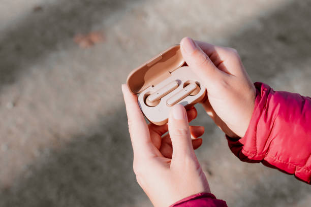 Woman holding open case with wireless earphones, top view Woman holding case with wireless earphones in beige color, top view 8571 stock pictures, royalty-free photos & images