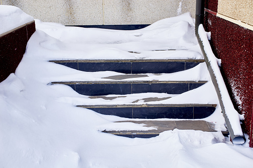 the staircase of the building, covered with snow after a heavy snowfall.