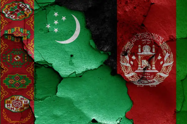 Photo of flags of Turkmenistan and Afghanistan painted on cracked wall