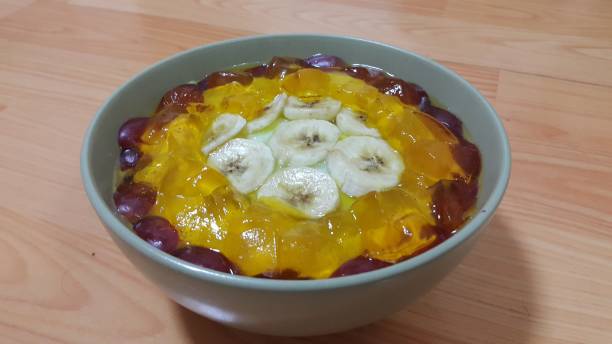 Creamy tasty sweet custard with banana pieces on surface inbowl on wooden floor Creamy tasty sweet custard with banana pieces layered on surface on wooden floor. A top view of home made custard, a dairy products for dessert after meal. hollandaise sauce stock pictures, royalty-free photos & images