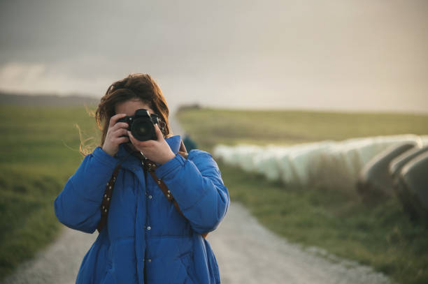 Young woman taking a picture with a DSLR camera outdoors