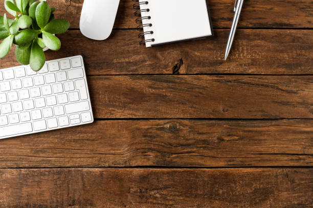 istock Office desktop with computer keyboard, mouse, notebook, pen and green plant on wooden table. Business background 1301577822