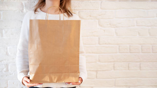 istock Woman holding a recyclable paper bag 1301578086