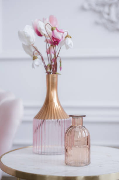 istock Pink flowers in a glass vase on a marble dressing table. Light interior. 1301580623
