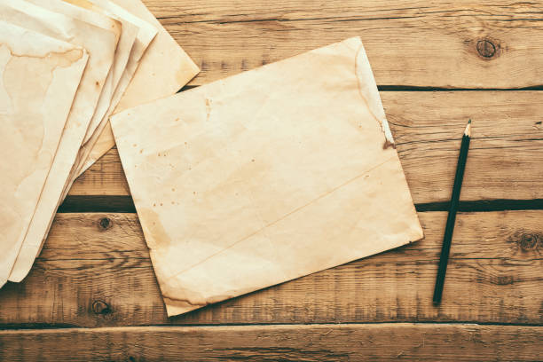 istock Sheets of old vintage paper on a wooden table. Copy space 1301583655