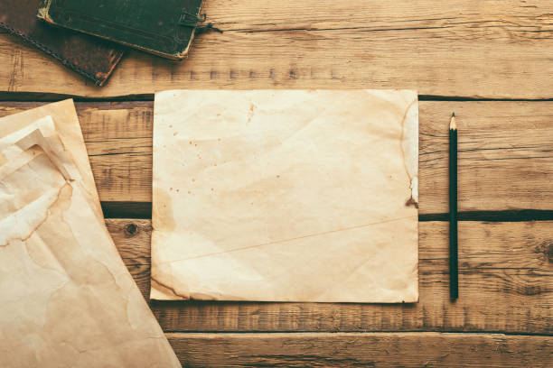 istock Sheets of old vintage paper on a wooden table. Copy space 1301583848