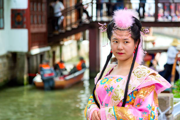 Chinese beautiful asian woman in national dress against Shanghai Zhujiajiao ancient Town in Shanghai, China. Chinese Venice. Shanghai, China - May, 2019: Chinese beautiful asian woman in national dress against Shanghai Zhujiajiao ancient Town in Shanghai, China. Chinese Venice Zhujiajiao stock pictures, royalty-free photos & images