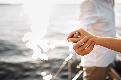 Hands of a couple in love on a yacht in the blue sea . High quality photo