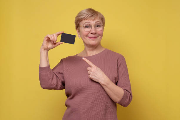 Smiling mature woman showing empty card in hand. stock photo