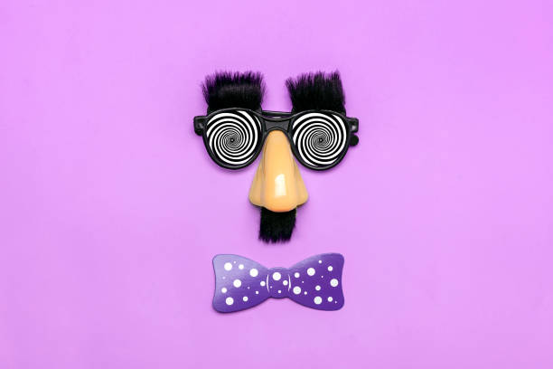 funny face - fake eyeglasses, nose and mustache, confetti, sequins on purple background Happy fools day concept 1st April party Holiday card funny face - fake eyeglasses, nose and mustache, confetti, sequins on purple background Happy fools day concept 1st April party Holiday card. magic trick photos stock pictures, royalty-free photos & images