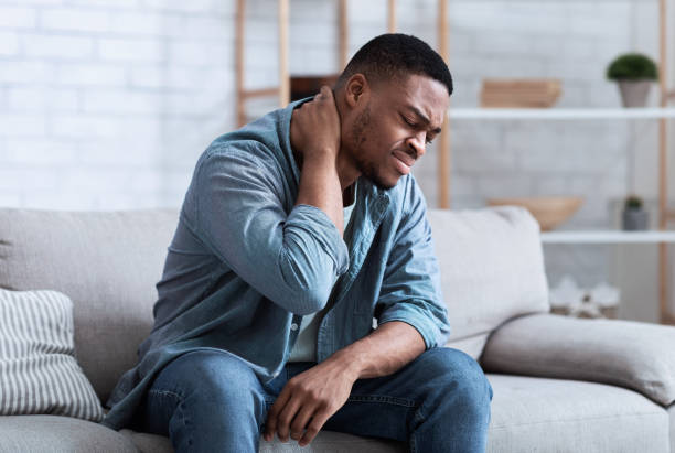 istock Black Man Suffering From Neck Pain Sitting On Couch Indoor 1301587364