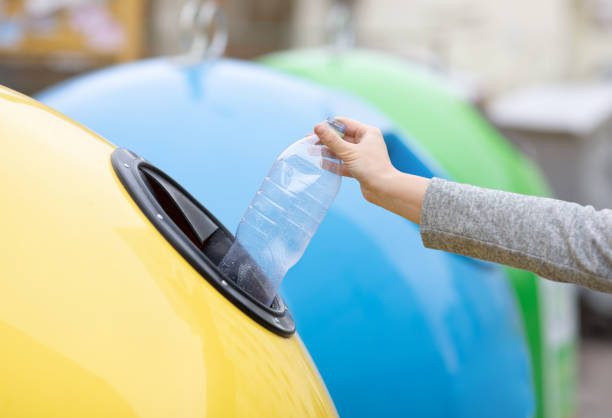 istock Waste Recycling Concept. Unrecognizable lady throwing plastic bottle into yellow recycle bin 1301587556