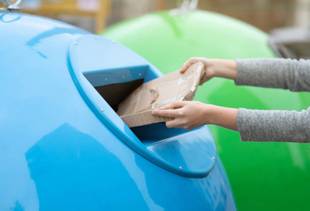 istock Paperwaste Sorting. Unrecognizable woman throwing carton package into blue garbage recycle bin 1301587621