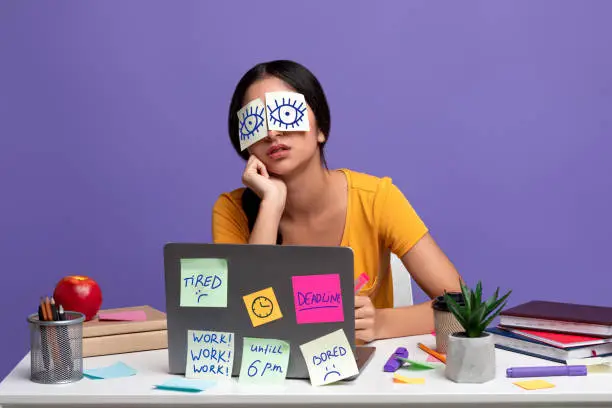 Photo of Tired indian woman sitting at desk with sticky notes