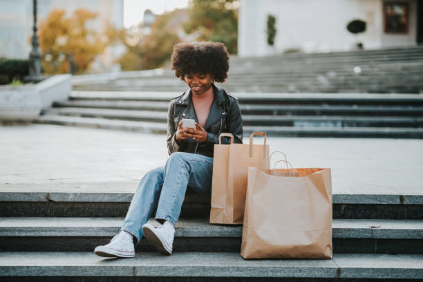 istock Happy afro woman using phone outdoors 1301588949
