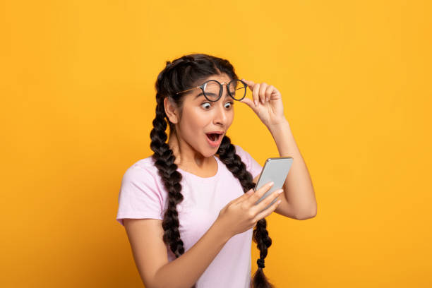 istock Excited indian woman using mobile phone, celebrating online win 1301590116