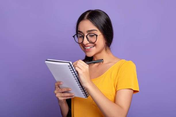 istock Woman holding pen writing in notebook at studio 1301590130
