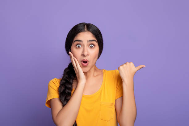 istock Excited indian woman pointing aside at copy space 1301590270