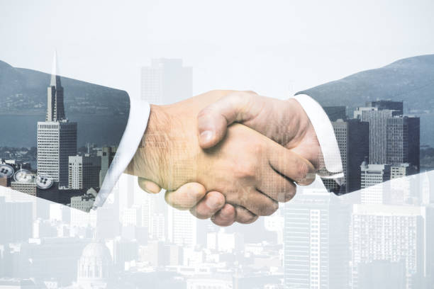 istock Multi exposure of handshake two businessmen on office buildings background, collaboration and teamwork concept 1301590783