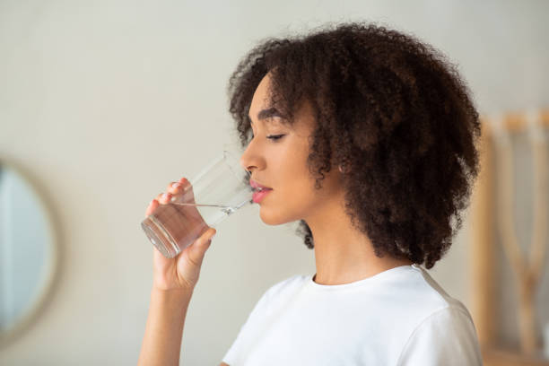 istock Thirsty woman holds glass drinks still water preventing dehydration 1301590833