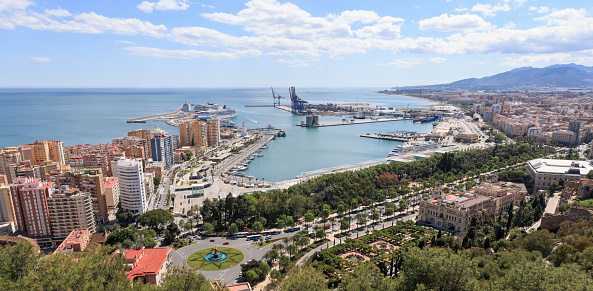 Málaga, Andalusia, Costa del Sol, Spain, April 22nd 2014, summer cityscape of Malaga, with focus on it's seaport in the Alboran Sea with 4 cruise ships and lots of smaller docked boots, seen from the-Castle-of-Gibralfaro - Málaga is the sixth most populous city in Spain, the port is the oldest continuously-operated port in the country
