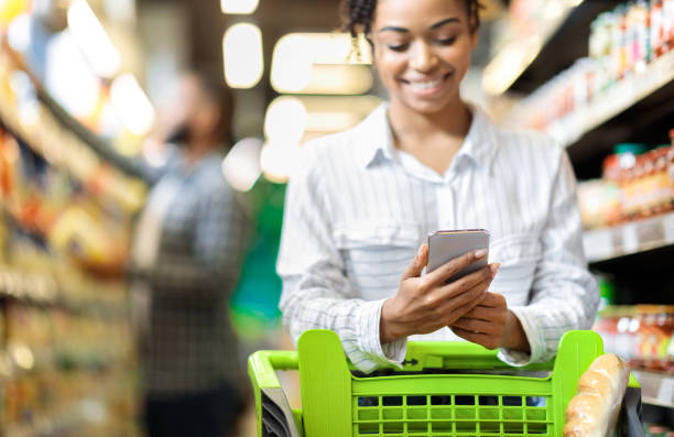 istock African Lady Customer Doing Grocery Shopping Using Smartphone In Supermarket 1301592024