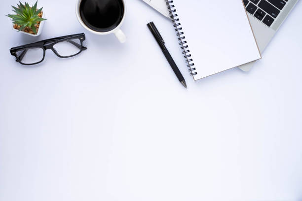 istock Top view above of White office desk table with keyboard laptop computer, notebook and coffee cup with equipment office supplies. Business and finance concept. Workplace, Flat lay with copy space. 1301592336