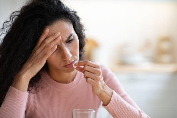 istock Upset Young Woman Taking Painkiller Pill While Suffering From Headache At Home 1301592352