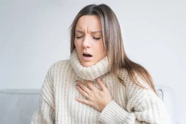 Photo of Woman having breath difficulties. Shortness of breath. Coronavirus cough breathing problem