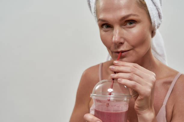 istock Middle aged caucasian woman in spa drinking smoothie 1301595006