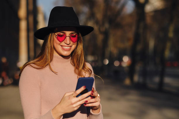 istock Woman using her mobile phone outdoors. 1301595136