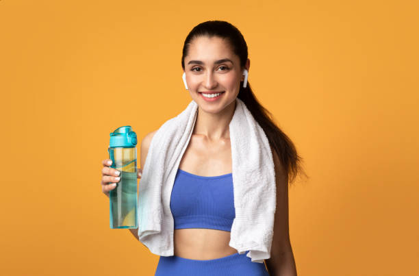istock Sporty woman looking at camera holding water bottle 1301595849