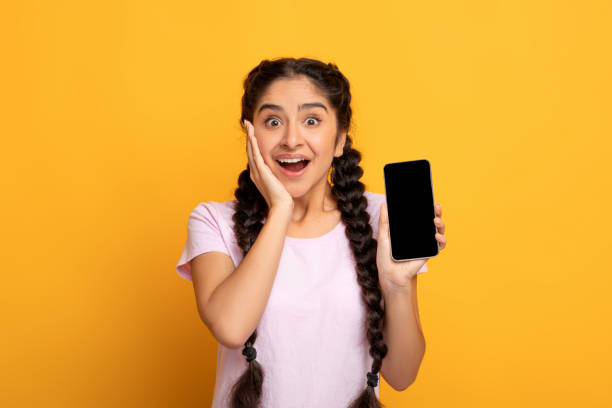 istock Surprised Indian woman showing blank smartphone screen 1301596982
