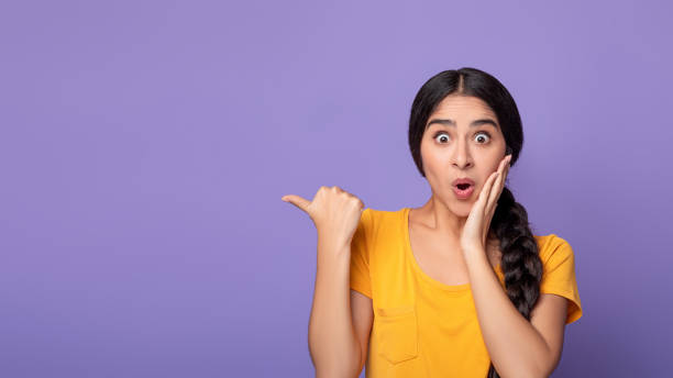 istock Excited young indian woman pointing aside at copy space 1301597943