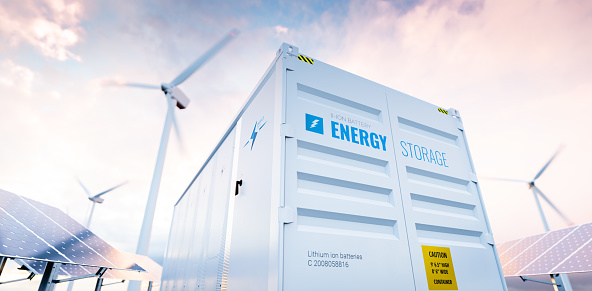 Imagen conceptual de un moderno sistema de almacenamiento de energía de batería con turbinas eólicas y centrales solares en segundo plano. Renderizado 3D photo